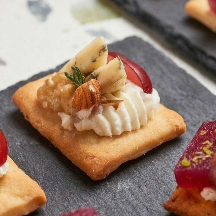 Канапе веганське сирне асорті з горішками та виноградом на крекері